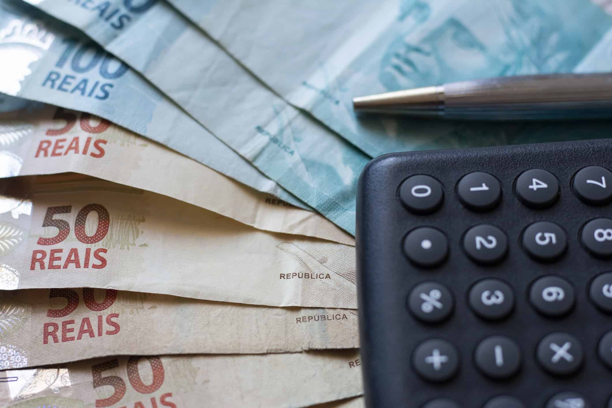 notas de dinheiro e calculadora mostram quanto ganha um corretor de imóveis